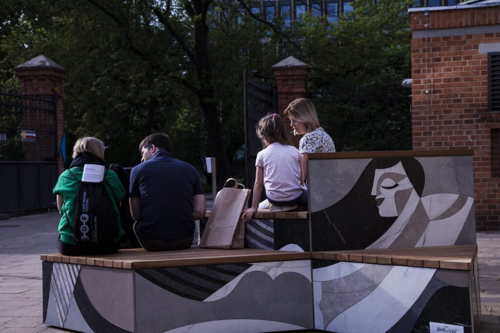The Relax in Lodz bench is an unusual urban furniture designed by Studio Izabela Bołoz with expressive illustrations by Kasia Bogucka. The innovation in the project was the use of ceramic tiles as a decorative material.

The furniture consists of five figures that form a modular block. In the design of the bench, 400 precision-cut, glazed tiles of various shades were used to clever effect in this public space. The friendly Iroko wood used on the seat surfaces invites both travelers and residents to rest comfortably before moving on.

The installation was created at the invitation of Łódź Design Festival and in cooperation with Ceramika Paradyż.